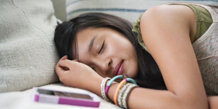 Teenage girl (13-14) asleep on sofa